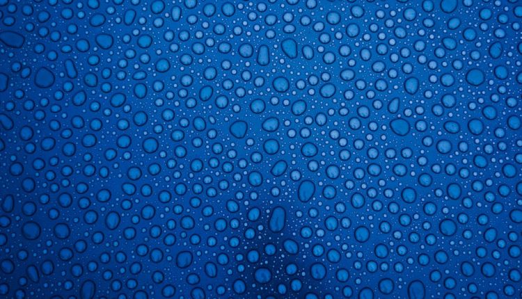 Macro shot of water droplets on a blue glass surface in Victoria, BC.
